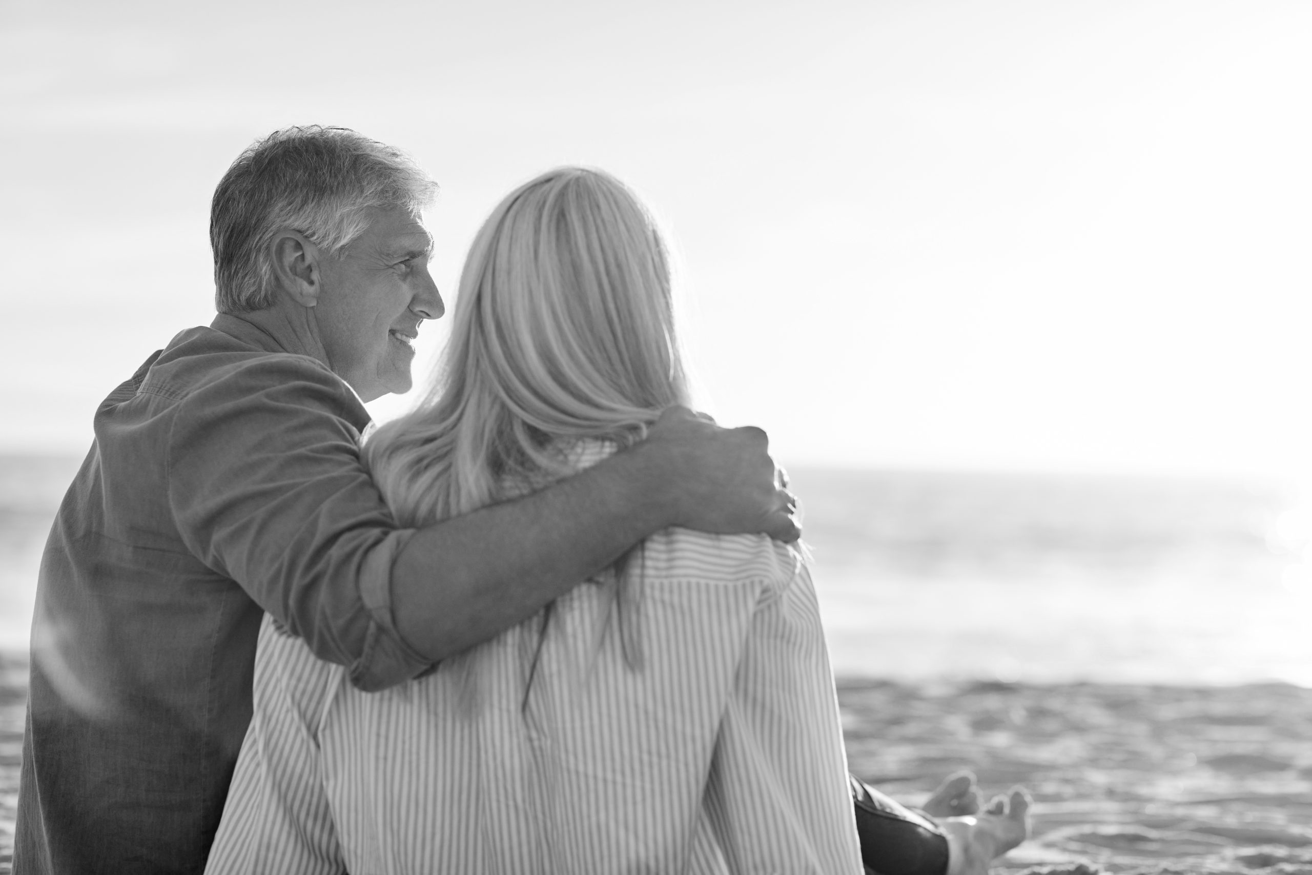 Gurley LTC Product Designs - Couple sitting on sandy beach during sunny day